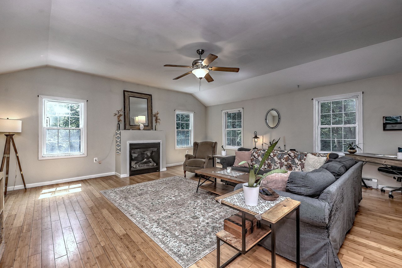 unwind beside the fireplace while vaulted ceilings and natural light create a warm, comfortable retreat.